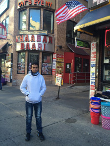 Jahed Ahmed stands on a street corner in Queens, where he currently lives while he is appealing deportation. 