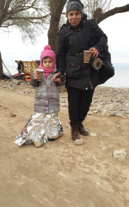 A refugee mother and daughter get warm after making the 6-mile journey on rubber dinghies. 